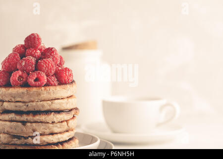 Vegan pancakes with raspberries and chia seeds on a white plate, white background. Healthy vegan food concept. Stock Photo