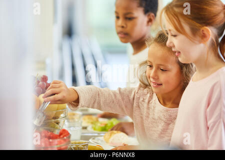 Children pick up food at the cafeteria buffet in kindergarten or elementary school Stock Photo