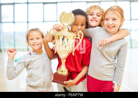 Group of children with trophy as successful winning team in elementary school Stock Photo