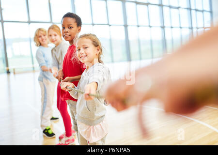 Group of children at tug of war in physical education in elementary school Stock Photo