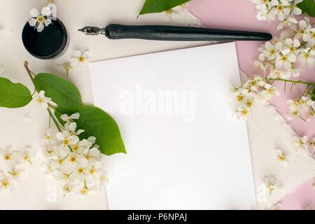 white paper sheet mockup with calligraphy nib and ink and white flowers branches. For invitation, wedding, decoration Stock Photo