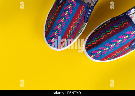bright multi-colored women's shoes on a yellow background. comfortable trend shoes for summer Stock Photo
