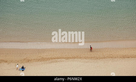 Two young couples spend time on sea coastline. Above view. Stock Photo