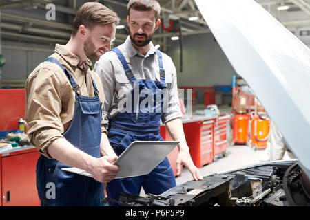 Two Mechanics Repairing Car Stock Photo