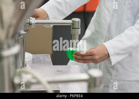 Technician filling container with liquid for laboratory tests Stock Photo