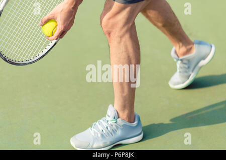 Low section of a professional player holding ball and tennis racket Stock Photo
