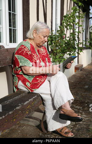 Elderly woman using a digital tablet. France. Stock Photo