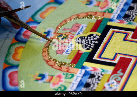 Tibetan monk working on sand mandala. Close-up. Stock Photo