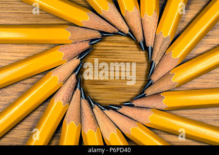 #2 Yellow Wood Graphite Pencils in a circle Radiating from their Points on a wooden desktop Stock Photo