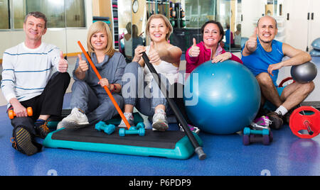 Active elderly men and women with fitness balls and dumbbells in a gym Stock Photo