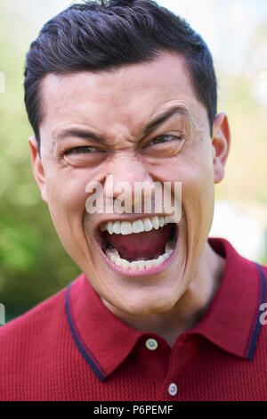 Outdoor Shot Of Angry Young Man Shouting At Camera Stock Photo