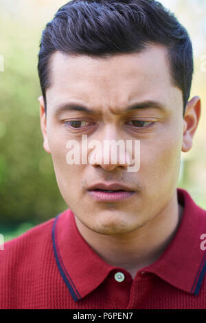 Outdoor Head And Shoulder Portrait Of Worried Young Man Stock Photo