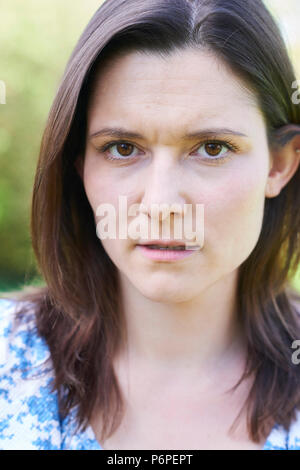 Outdoor Head And Shoulder Portrait Of Worried Young Woman Stock Photo