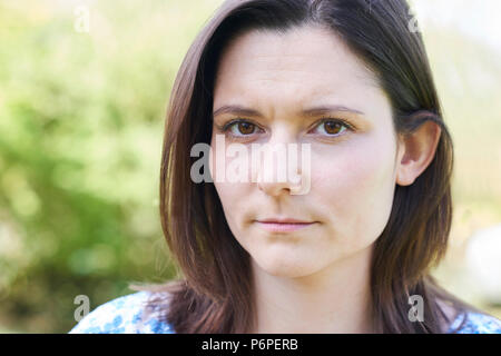 Outdoor Head And Shoulder Portrait Of Worried Young Woman Stock Photo