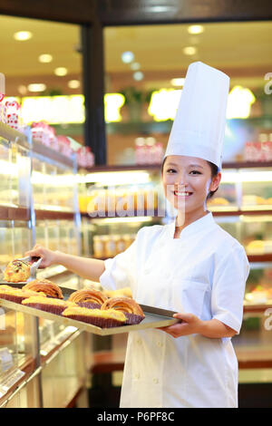 female baker in bakery working Stock Photo