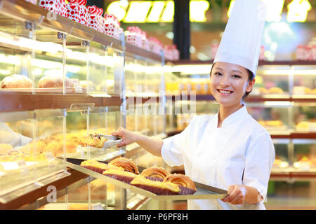female baker in bakery working Stock Photo