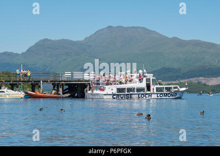 Loch Lomond - Luss Pier on a hot summer day with Ben Lomond behind, with Cruise Boat  picking up passengers, Scotland, UK Stock Photo