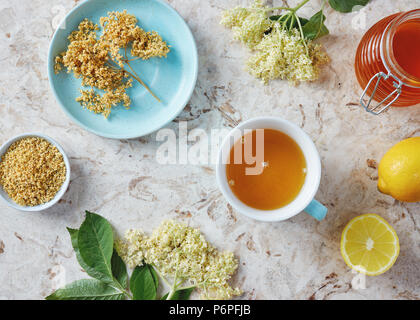 Cup of elderflower tea with fresh and dried flowers Stock Photo
