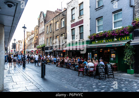 Customers dining al fresco at row of restaurants on Berwick Street, Soho, London, England, UK. Stock Photo