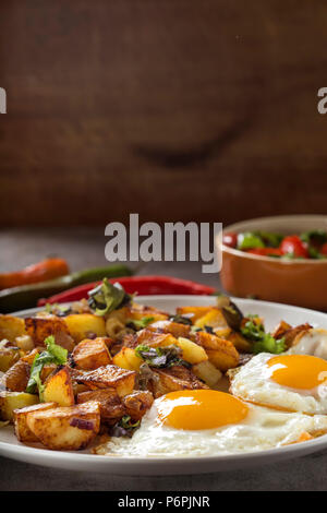 Eggs and Fries with small pieces of fat pork meat, onion and garlic on plate Stock Photo