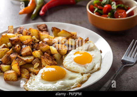 Eggs and Fries with small pieces of fat pork meat, onion and garlic on plate Stock Photo