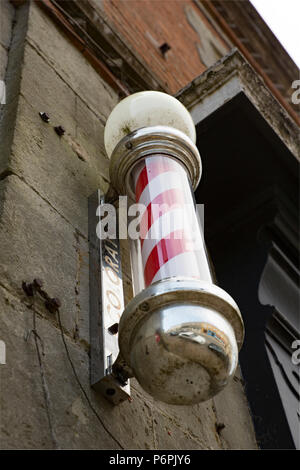 A red and white Barber’s pole or sign, outside a barber’s shop in Shaftesbury. The barber’s pole has a history dating back centuries. Shaftesbury Nort Stock Photo