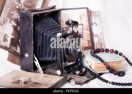 Retro camera and old pictures on the table. Retro photo and vintage. Stock Photo