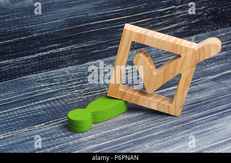 The green man lies crushed under the checkbox. The concept of repression, the pressure of the state machine. The law against respectable people, oppre Stock Photo