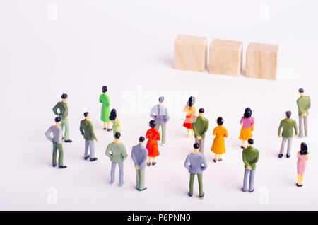 People are looking at a standing three wooden cube with letters on a white background. Place for letters on the squares. template for a three-letter w Stock Photo