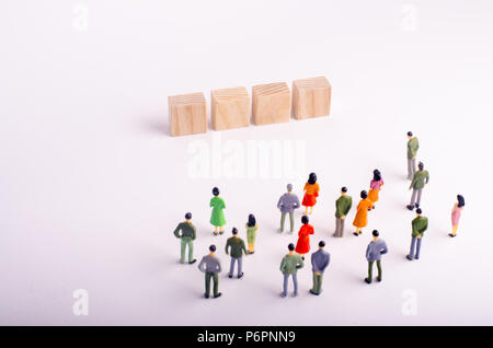 People are looking at a standing four wooden cube with letters on a white background. Place for letters on the squares. template for a four-letter wor Stock Photo