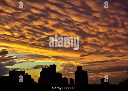 Colourful sunset in the city with fiery mammatus clouds Stock Photo