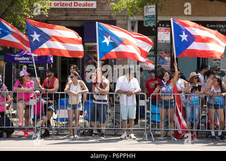 Chicago, Illinois, USA - June 16, 2018 A group of spectators wave the Puerto Rican flag during the Puerto Rican People's Parade Stock Photo