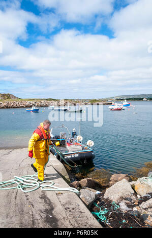 Burtonport, County Donegal, Ireland weather. 2nd July 2018. The warm weather continues with a cooling breeze in the harbour on Ireland's north-west coast. An inshore fisherman moors his boat in foreground. Credit: Richard Wayman/Alamy Live News Stock Photo