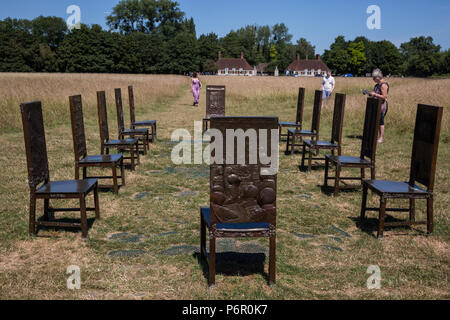 Runnymede, UK. 2nd July, 2018. Tourists enjoy Hew Locke's The Jurors on a sunny morning alongside the river Thames. The artwork comprises twelve intricately worked bronze chairs standing in an ancient meadow. Credit: Mark Kerrison/Alamy Live News Stock Photo