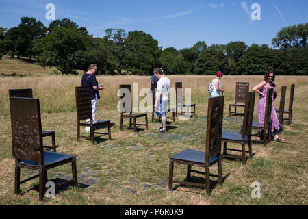 Runnymede, UK. 2nd July, 2018. Tourists enjoy Hew Locke's The Jurors on a sunny morning alongside the river Thames. The artwork comprises twelve intricately worked bronze chairs standing in an ancient meadow. Credit: Mark Kerrison/Alamy Live News Stock Photo