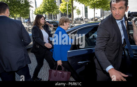 Berlin, Germany. 02nd July, 2018. German Chancellor Angela Merkel (CDU) leaving the Bundestag (Federal Legislature) with her bodyguards. Credit: Michael Kappeler/dpa/Alamy Live News Stock Photo