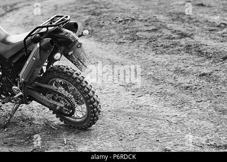 Offroad mountain motorcycle or bike taking part in motocros competition parked on dirty terrain road Stock Photo