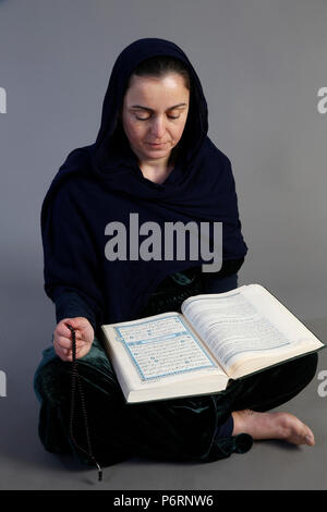 Woman reading Kuran. Paris, France. Stock Photo