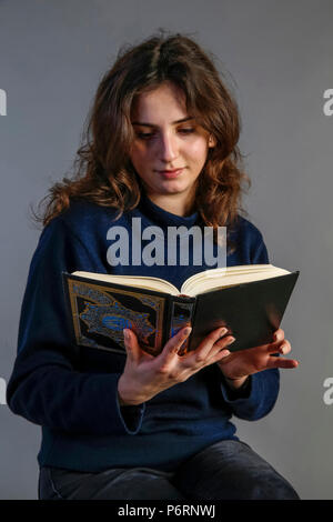 Young woman reading kuran. Paris, France. Stock Photo