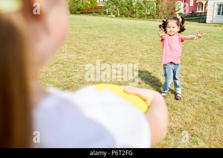 Little Asian Girl Playing Frisbee Stock Photo