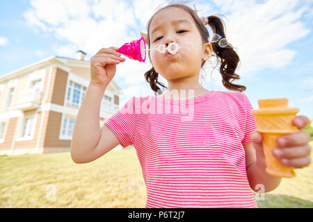 Cute Asian Girl Blowing Bubbles Stock Photo