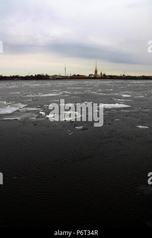 Golden spire of the Peter and Paul Cathedral, seen from the Neva river in St. Petersburg, Russia, with some ice shelves on the water surface Stock Photo