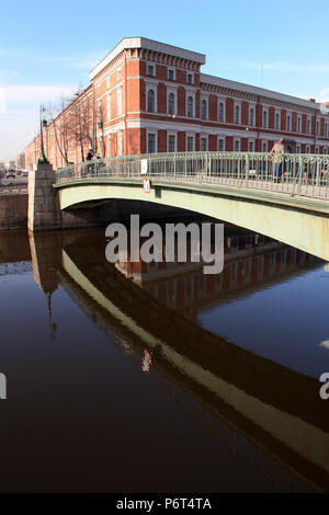 Bridge across the Griboyedov canal in St. Petersburg, Russia, with a historic building in the background Stock Photo