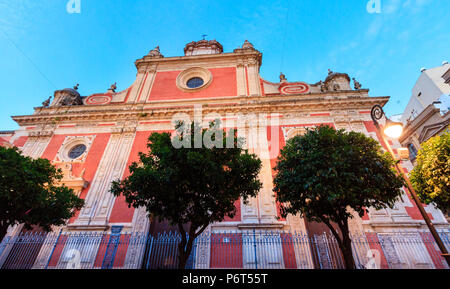 SEVILLE, SPAIN - May 26, 2016:  Red facade of the Church of Saviour (1674-1712) at Plaza del Salvador in evening, Seville, Spain. Architects Esteban G Stock Photo