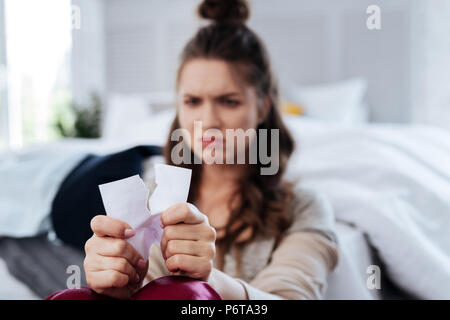 Sad young woman tearing photo with ex boyfriend Stock Photo