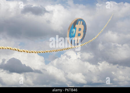 Bitcoin balancing on rope in the sky. Stock Photo