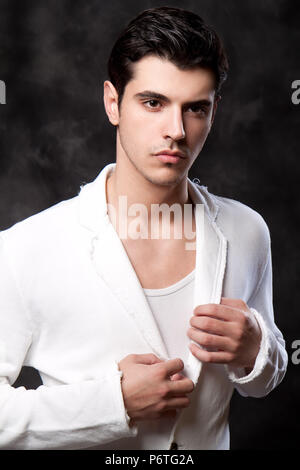 Handsome young man posing in white jacket Stock Photo