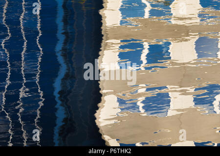 Reflection of a house with many windows and blue sky on moving water Stock Photo