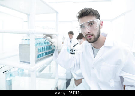 Young male scientist looking at a sample in a test tube side vie Stock Photo