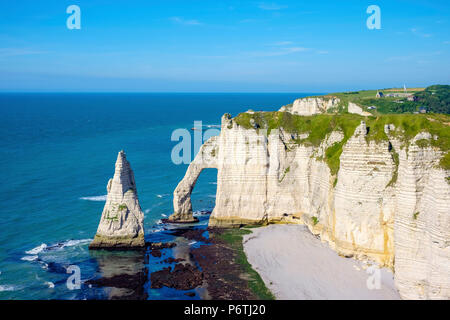 France, Normandy (Normandie), Seine-Maritime department, Etretat. White chalk cliffs and Aiguille d'Etretat, natural stone arch on the coast. Stock Photo